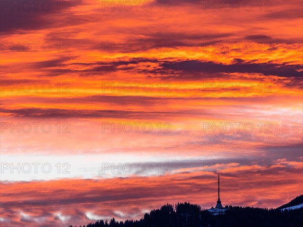 Clouds above the summit of the Mugel in the morning red at sunrise