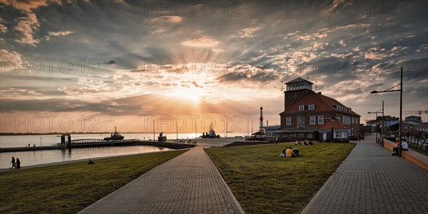 View of the Weser estuary and Strandhalle at sunset from the dyke