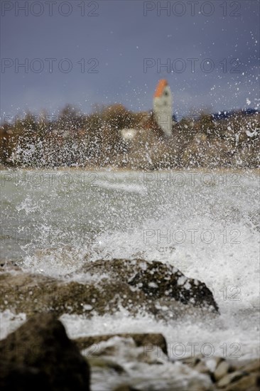 Storm Lolita whips waves against the stony shore in the background Hagnau