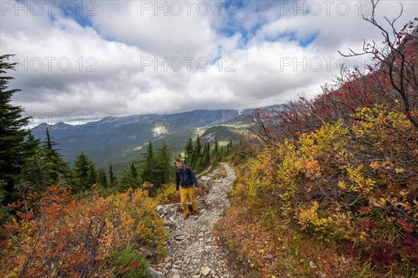 Hikers on a trail through autumn coloured bushes