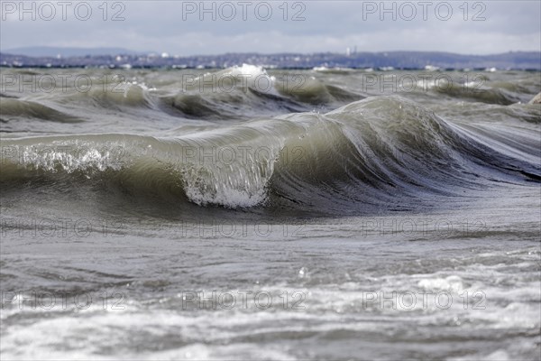 Storm Lolita raging on the rocky shore with waves in Hagnau