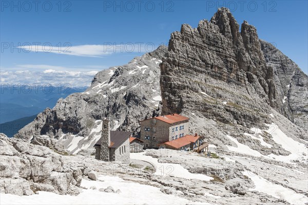 Alpine refuge Rifugio Pedrotti and chapel with rock Croz del Rifugio