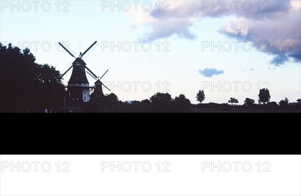 Silhouettes of the twin mills Greetsiel in the evening light