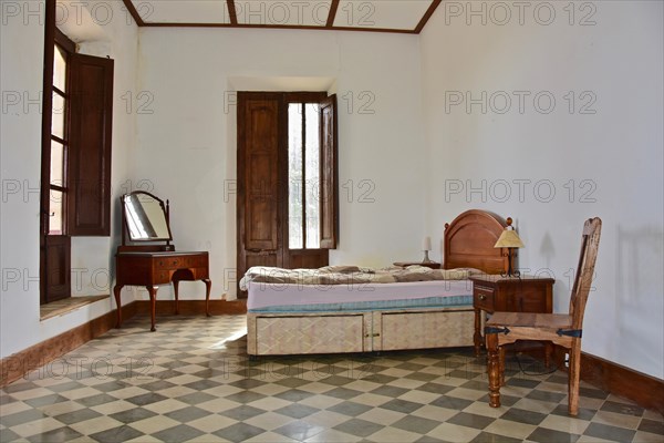 Bedroom with mirrored chest of drawers in bourgeois house in Spain