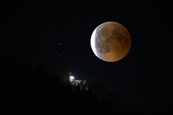 Lunar eclipse over the mountain station of the Saentisbahn