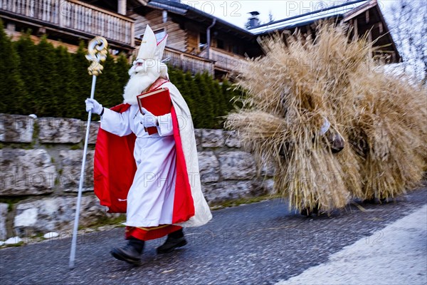 Santa Claus with Buttnmandl walking through a street