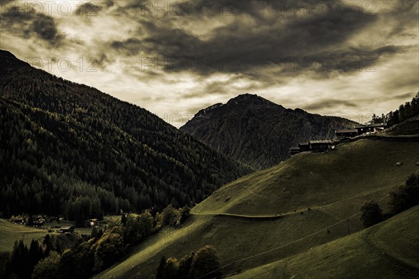 Old farms on a mountain meadow with mountains in the background