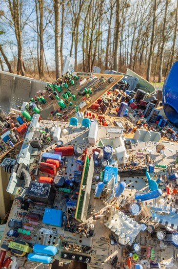 Polluting plastic waste and computer scrap illegally disposed of in a meadow