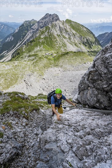 Young man climbing in via ferrata