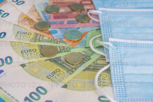 Medical masks and Euro currency banknotes. Financial crisis due to Coronavirus losses
