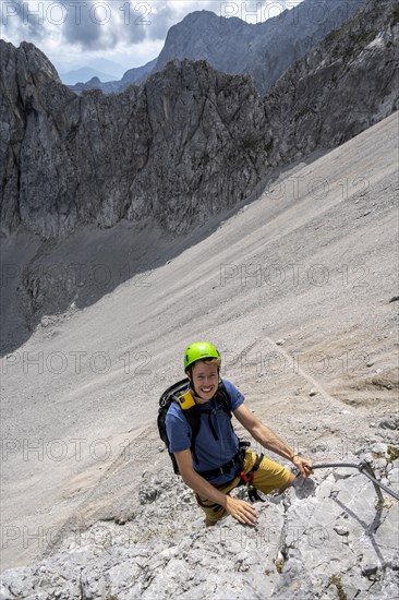 Young man climbing in via ferrata