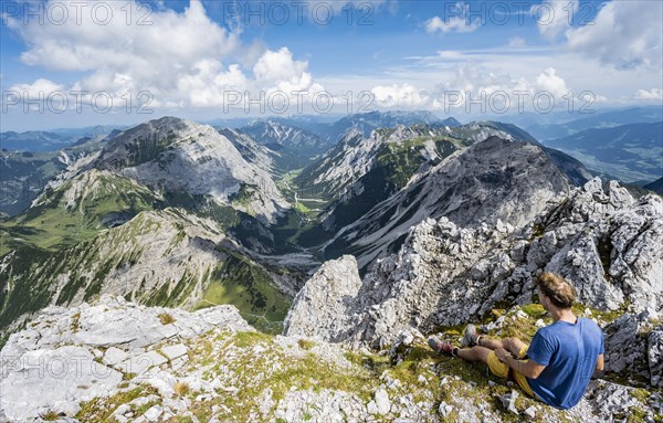 Hiker sitting at the summit of the Lamsenspitze