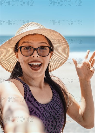 Pretty girl taking a selfie on the beach