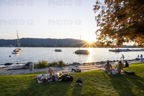 People sunbathing on the shore of Lake Zurich