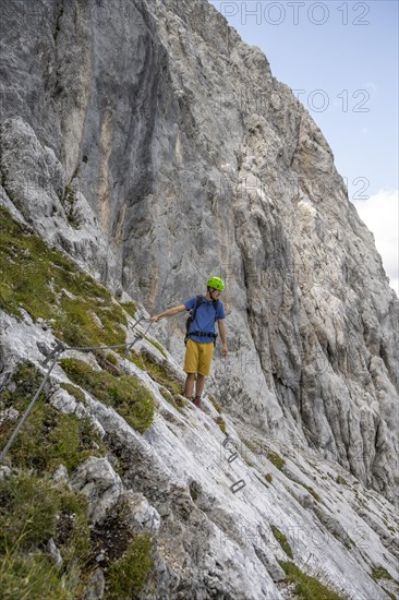 Young man climbing in via ferrata