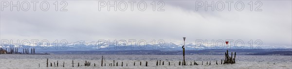 Old wooden groynes at low water and storm on Lake Constance