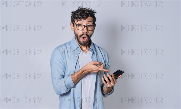 Young man showing blank cell phone screen