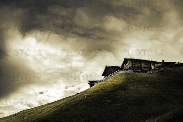 Old farms on mountain meadow with dramatic light