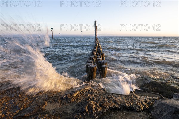 Waves crashing against the shore fortification in the harbour of Guettingen