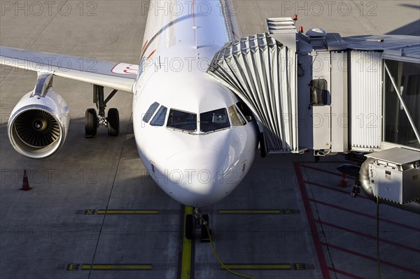 Aircraft Swiss with docked passenger boarding bridge