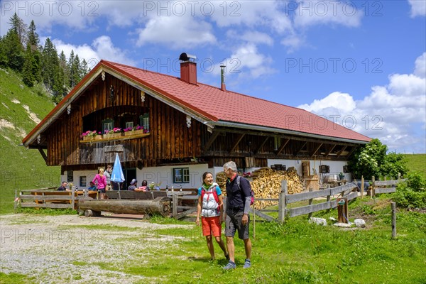 Hikers in front of the Rettenbeck Alm