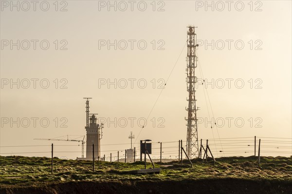 Lighthouse with radar antenna and radio tower in the evening light