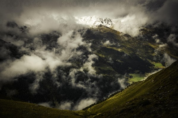 Mountain landscape in fog with dramatic clouds