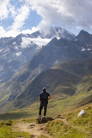 Hiker looking into the mountain massif of the Oetztal Alps in the rear Passeier Valley