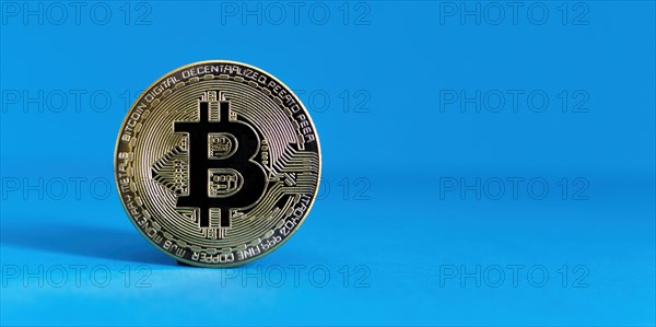 Bitcoin BTC crypto currency gold coin on blue background