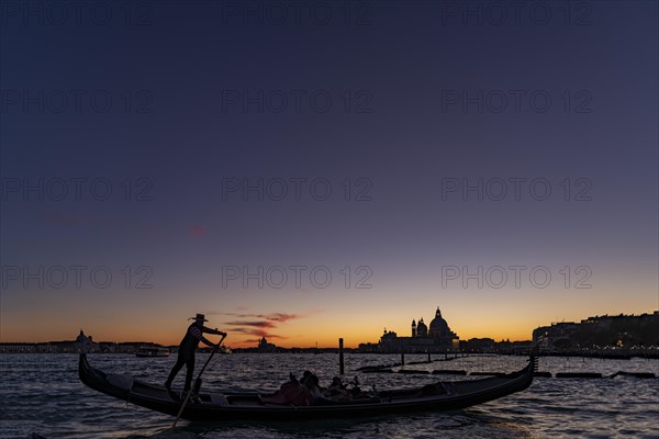 Gondolier with gondola in the sunset
