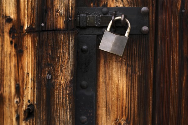 Padlock on the gate of a wooden barn