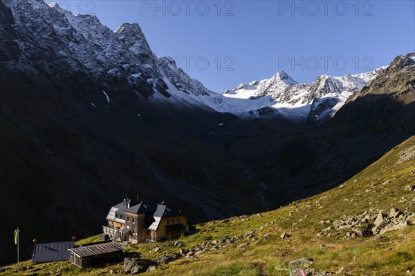 Westfalenhaus in front of on mountain meadow in front of snowy peaks of the Sellrain mountains