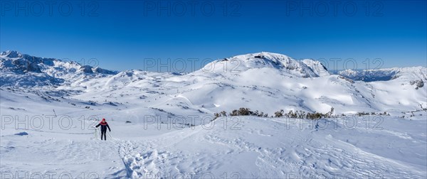 Blue sky above snowshoe hiker in winter landscape