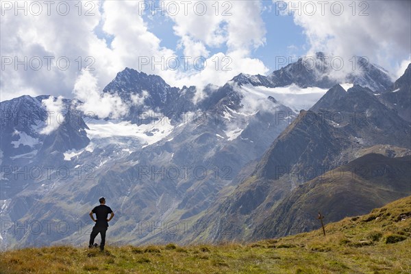 Hiker looking into the mountain massif of the Oetztal Alps in the rear Passeier Valley