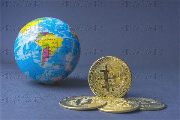 Bitcoin BTC crypto currency gold coins and Earth globe