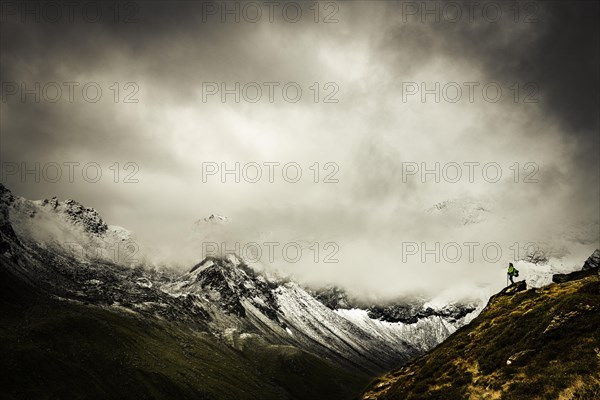 Mountaineers in front of dramatic clouds in mountain landscape