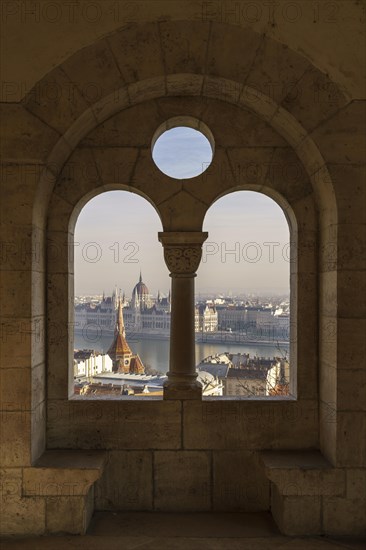 View through an arched window of the Fishermen's Bastion onto the Danube with the Parliament Building