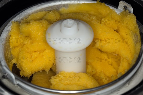 Frozen mango sorbet in an ice cream machine