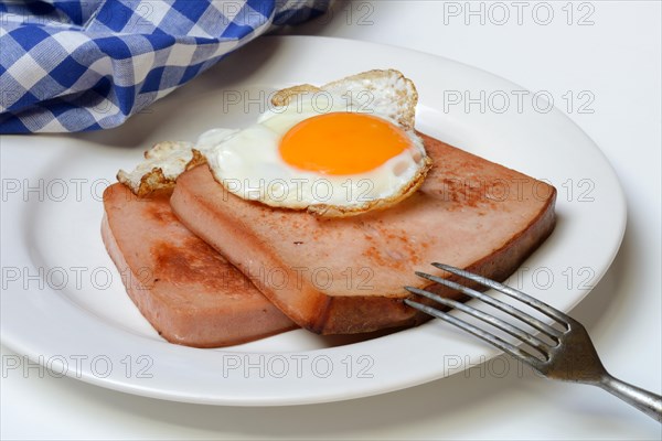 Two slices of meat loaf with fried egg on plate