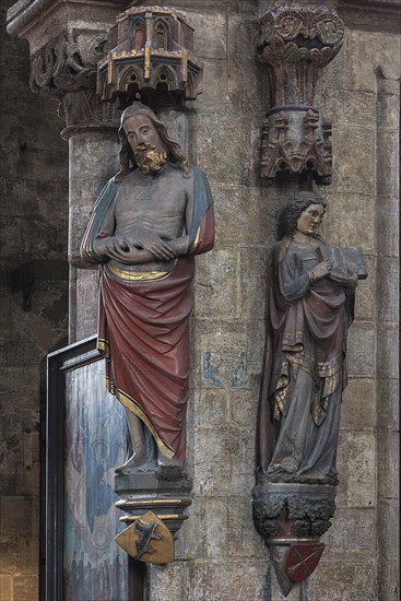 Coloured sculptures of the Man of Sorrows on the left and holy St. Matthew on the right