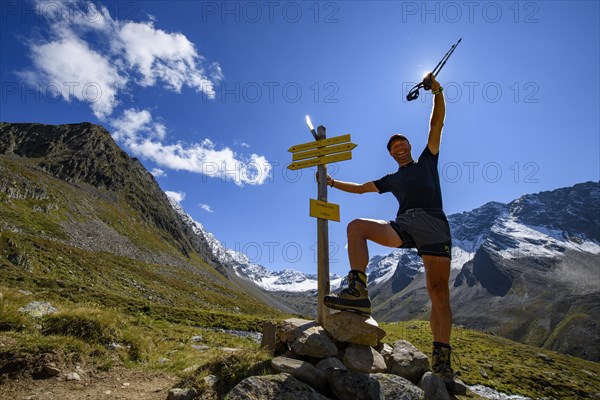 Mountaineers at trail markings in the backlight and Sellrain mountains in the background