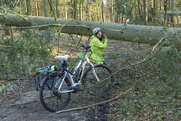 Woman cycling through the forest on an e-bike after a storm