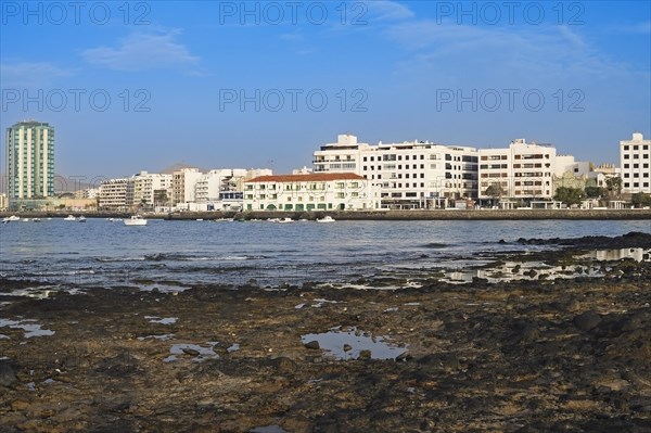 Houses on the harbour promenade with Grand Hotel Arrecife