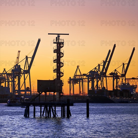 Radar tower and loading cranes at the container terminal Burchradkai at sunset