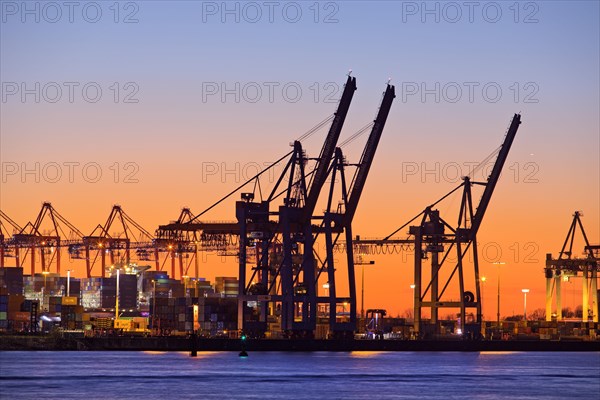 Loading cranes at the container terminal Burchardkai at sunset