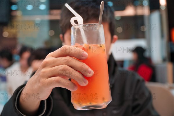 Hand holding grapefruit juice in a glass