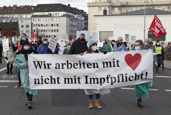 Nursing staff carrying banner We work with heart not with compulsory vaccination