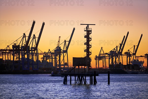 Radar tower and loading cranes at the container terminal Burchradkai at sunset