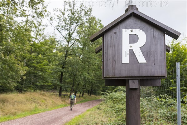 Marker on the Rennsteig with hiker