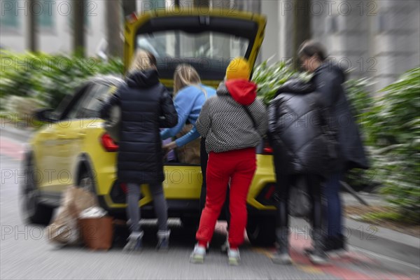 Wiping picture People stow luggage in car trunk